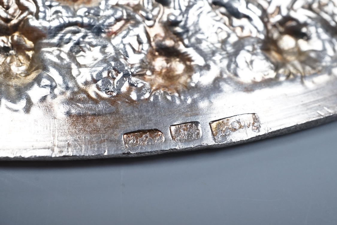 A 20th century Middle Eastern white metal circular dish and cover, embossed with flower heads, stamped '84', base diameter 24.2cm, 28.2oz.